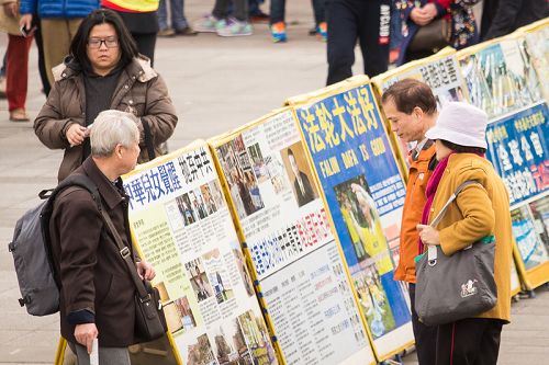 图5-6:与此同时,学员们在活动现场摆放了真相展板,吸引众多民众与国外游客、尤其是中国大陆游客驻足观看。