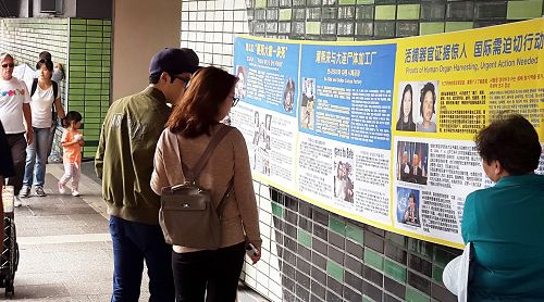 图1-2:许多当地民众纷纷驻足了解真相,观看法轮功被迫害真相的系列横幅。