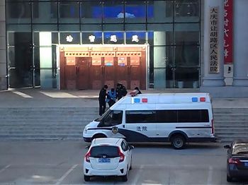 图3:庭审结束后,警察从法院的法官通道大门带出林华文