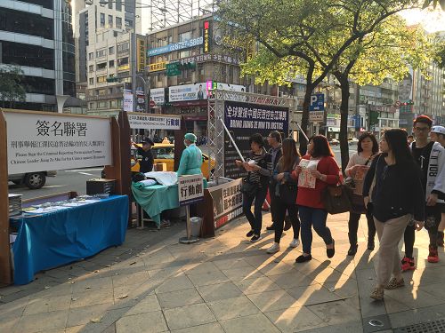 图1-2:三月六日,台北忠孝东路商圈的街头,法轮功学员举办揭露中共迫害的活动,吸引民众关注