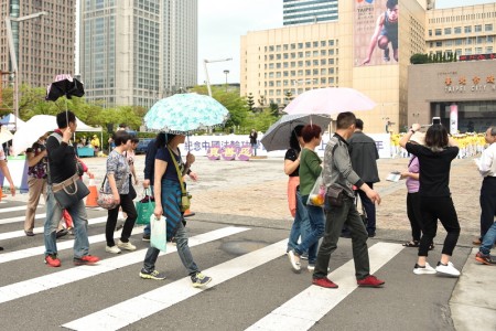 图7-8:法轮功学员在台北市政府前的市民广场举办纪念四二五和平大上访十七周年活动,吸引大陆游客拍摄观看