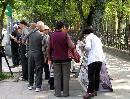 图5:中国游客仔细聆听法轮功学员讲真相。