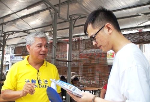 图5: 路人聆听法轮功学员讲真相。