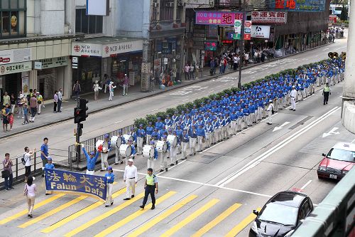 图6-8:法轮功学员的游行队伍由天国乐团前导,吸引道路两侧的广大民众驻足围观及拍照。