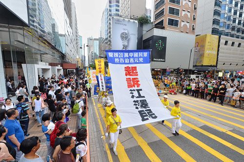 图15-20:法轮功学员希望民众了解真相,在游行队伍中打出了揭迫害、唤良知、启善念、劝三退,及全球控告迫害元凶江泽民等横幅。