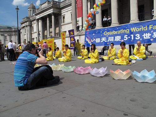 图13:经营摄影室的伦敦人保罗了解法轮功真相,五月八日,在鸽子广场再次被法轮功学员集体炼功讲真相的场面所吸引。