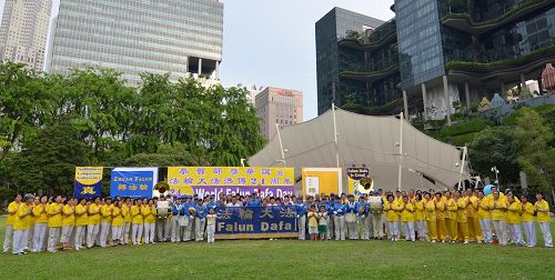 图1:新加坡法轮功学员集体合影,恭敬合十,齐声念颂:“新加坡大法弟子恭祝师尊生日快乐,谢谢师父!”