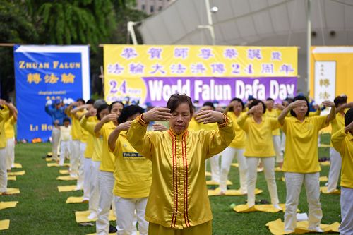 图2-3:新加坡法轮功学员集体炼功庆祝世界法轮大法日,与民众分享大法的美好。