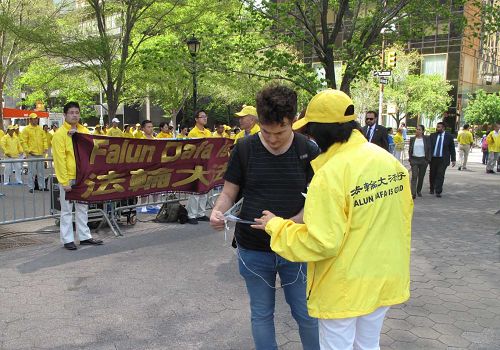 图5-8:法轮功学员祥和的炼功场面,吸引来往匆匆,到联合国或办事、或参观的民众放慢脚步,有的观看,有的驻足了解真相。了解真相后的民众签名支持制止迫害。