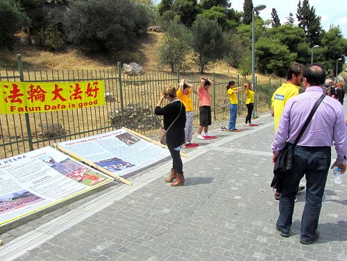 图2-3:法轮功学员展示功法并向游客讲真相