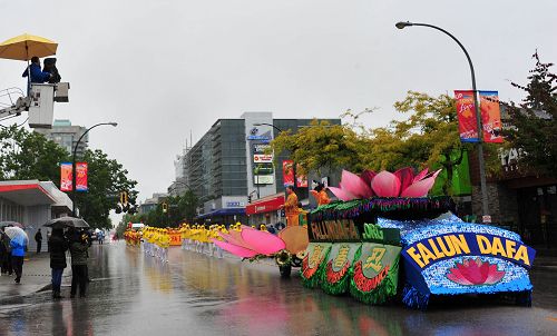 图4:电视台和观众冒雨拍摄法轮功学员游行队伍。
