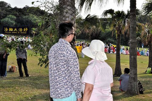 图9:一位来自大陆的年轻人站在后面树林下静静地观看法轮功炼功良久,很是认同,并以化名退出共青团。