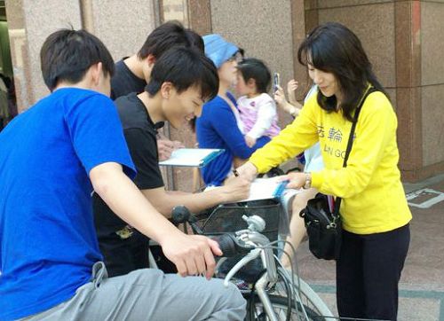 图1-2:日本法轮功学员在福冈天神征集声援起诉迫害元凶江泽民的签名。许多民众签名后,并对法轮功学员说:我们支持你们。