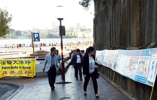 法轮功学员在悉尼歌剧院景点设立真相点,大陆游客经过时,许多人观看真相横幅。