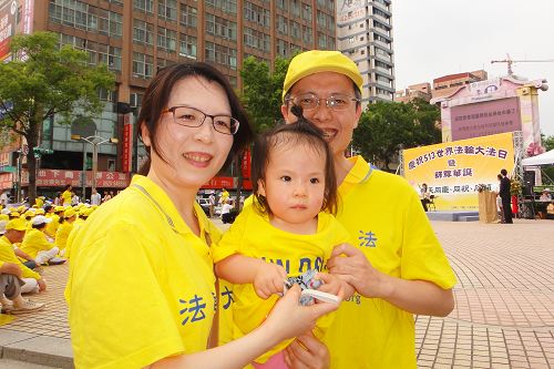 图9:韦志龙带着妻子及一岁多的女儿参加世界法轮大法日活动。