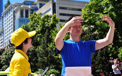 图10:华裔黄先生(身穿蓝衣者)路过活动现场,跟随法轮功学员完整炼了法轮桩法,他炼完后表示感觉能量很强。
