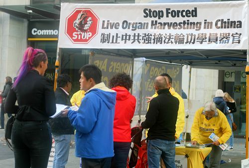 图2-5:许多过往民众驻足了解真相,并签名支持制止中共活摘法轮功学员器官的罪恶。