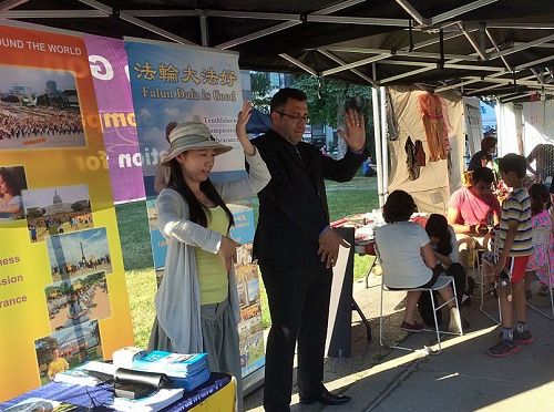 图3 :法轮功学员在多伦多国际村节上设立展位,向民众介绍法轮功及其真相。有的民众马上学炼功法。