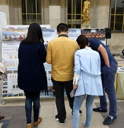 图3:巴黎人权广场上,中国大陆游客观看法轮功真相展板