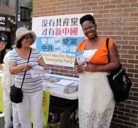在费城多家医院做助产士的Dominique Richaidson女士(右1)索要了一些法轮功功法介绍和真相资料