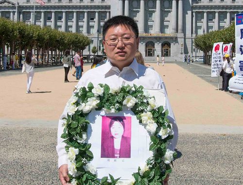 图:10 手持被迫害致死同修花圈的法轮功学员高睿