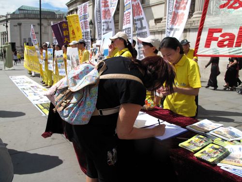 二零一六年七月十六日,在位于特拉法加广场的法轮功反迫害集会现场,一位女士听了伊森•葛特曼的发言后立即走到信息台前签名反活摘、反迫害