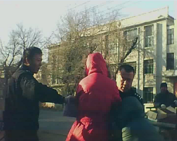 警察周佳佳(左)、张维富(右)正在抢掠祖孙二人手中的物品,老人渐渐倒地。