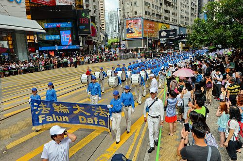 “图2:天国乐团引领法轮功学员队伍,游行从港岛区英皇道、轩尼诗道,途经闹市铜锣湾、湾仔、中环,最终到西环中联办,历时三个多小时,沿途吸引港民及中西旅客观看。"