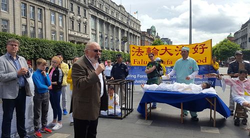 图3:爱尔兰参议院资深参议员大卫•诺瑞斯在集会上呼吁民众签名支持法轮功,制止活摘和迫害:“所有的人,建议你来看看这些信息展板,并且签上你的大名。”