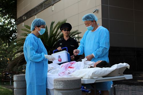 法轮功学员现场展示模拟活摘器官,揭露中共罪恶