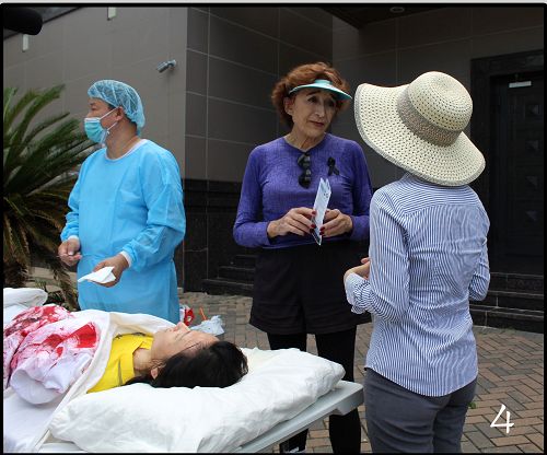 阿灵女士(中)知道真相后,动地在签字板上签名支持停止迫害法轮功。