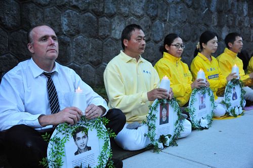 图2:温哥华知名博客博主Dennis Watson先生(左一)来到中领馆前,加入法轮功学员的烛光悼念。他说:“在十七年残酷迫害下坚忍不屈地抗争,体现了你们的大忍精神,我的心和你们在一起抗争。”