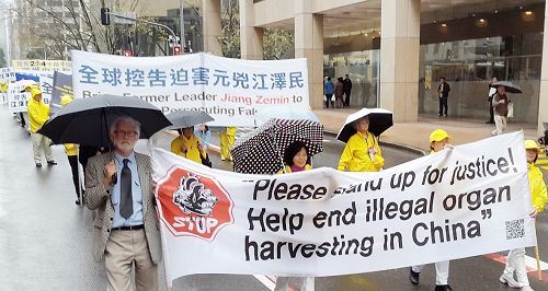 图16:人权活动家鲍勃•维尼康博(Bob Vinnicombe)先生(左一)冒雨全程跟随法轮功学员游行