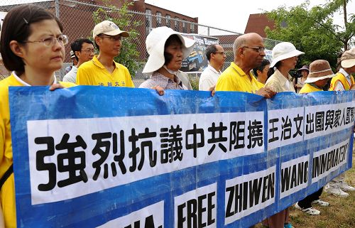 渥太华部分法轮功学员冒雨在中共驻加使馆前,抗议中共阻挠法轮功学员王治文出境,前往美国与家人团聚,并呼吁法办江泽民、曾庆红等迫害元凶。