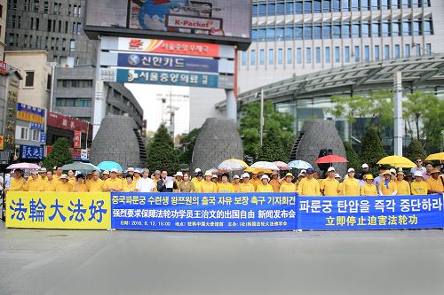 '八月十二日下午三点,韩国部份法轮功学员在中共大使馆前举行集会,敦促中共当局重新颁发护照,还给王治文自由,使其与家人团聚。'