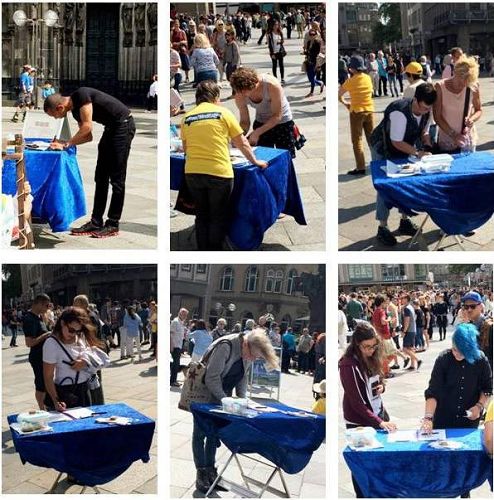 '图1:科隆大教堂广场上的法轮功信息展位上,人们纷纷驻足签名支持法轮功'