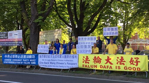 '图:比利时法轮功学员在中使馆前抗议,谴责中共犯罪集团剪毁王治文护照,阻挠王志文出国与女儿团聚,以及持续迫害法轮功学员的罪行。'