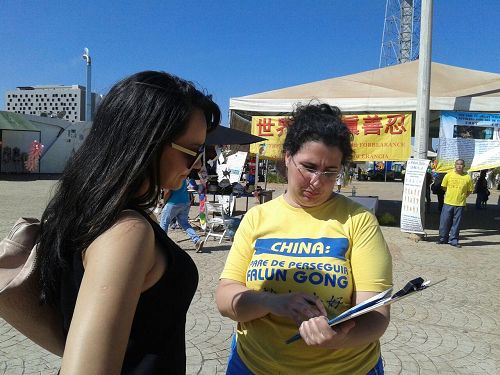 '图9:这位年轻的母亲看着法轮功资料说:“这就是我要找的。”'