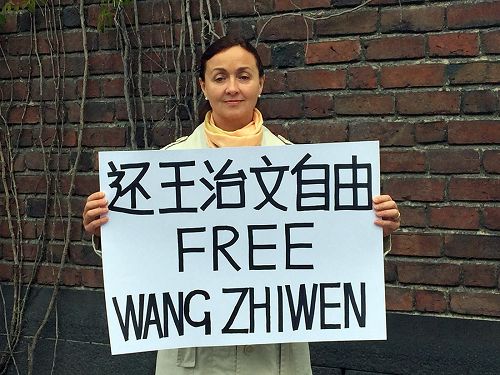 '图2、法轮功学员克里斯蒂娜(Kristina)代表全家抗议中共阻挠王治文赴美与家人团聚'