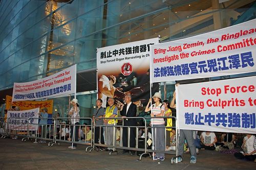 '图1:法轮功学员在国际器官移植协会(TTS)国际大会场外拉起真相横幅、举行集会,呼吁制止中共活摘器官罪恶。'