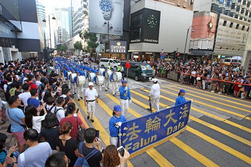 '图4:由法轮功学员组成的队伍,在天国乐团引领下,游行九龙区旺角、佐敦,再到尖沙咀广东道,抵达终点天星码头。沿途吸引港民及中西旅客观看。'
