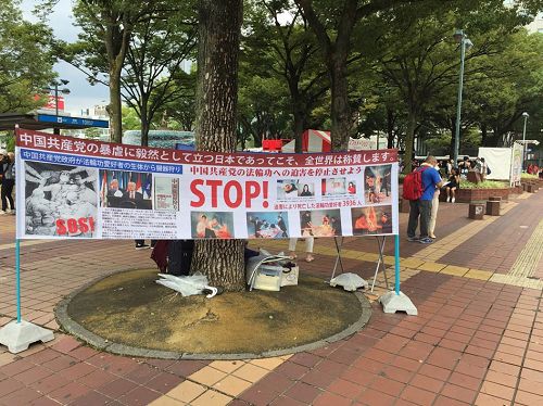 '图1:法轮功学员在日本名古屋繁华街边一角,挂起了反迫害的条幅'
