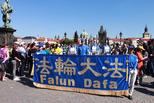 '图4:在著名的查理大桥上人们驻足观看法轮功学员的演出及打出的横幅'