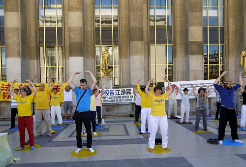 图1-5:二零一六年八月七日星期日下午,法国法轮功学员在巴黎人权广场传播法轮功的真相,许多游客驻足了解。