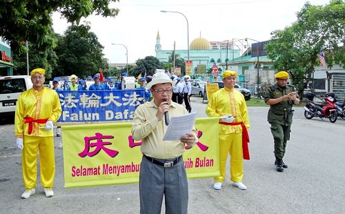 '图1:活动的主要负责人刘先生在游行开始时,向民众介绍法轮功。'
