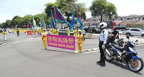 '图6:马来西亚法轮功学员来到雪兰莪州班丹英达(Pandan Indah)举办庆中秋游行活动,交通警察和自愿警卫队前来提供协助,为法轮功游行队伍开路。'