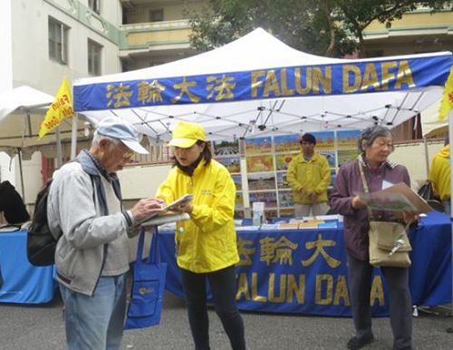 '图1:二零一六年九月十日和十一日,法轮功学员在旧金山中国城的“中秋街会”上设立展位,向民众讲述法轮功的真相,并征集“制止中共活摘”的签名。许多华人签名支持。'