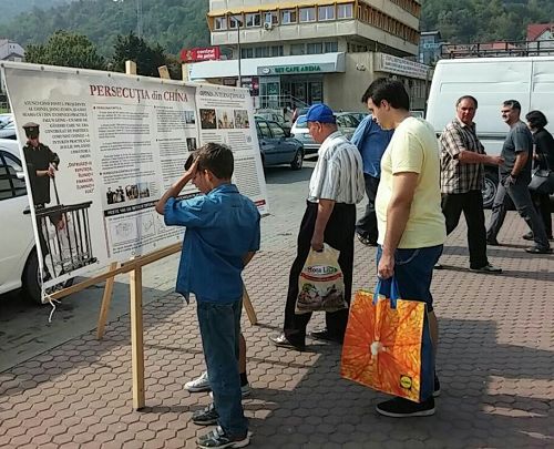 '图1:民众认真阅读法轮功真相展板'