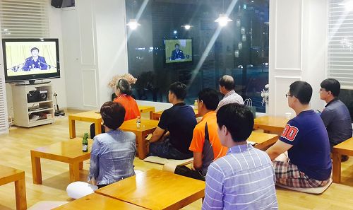 '图:新入门的学员在首尔天梯书店三楼观看法轮功创始人李洪志先生的讲法录像'
