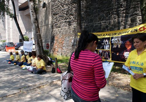 图2:墨西哥学员向过往民众讲述法轮功的真相,并征集反活摘签名。